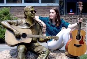 Emma Spies, the 2016 Danny DeGennaro Foundation scholarship winner, poses with a sculpture of Danny DeGennaro at Bucks County Community College.